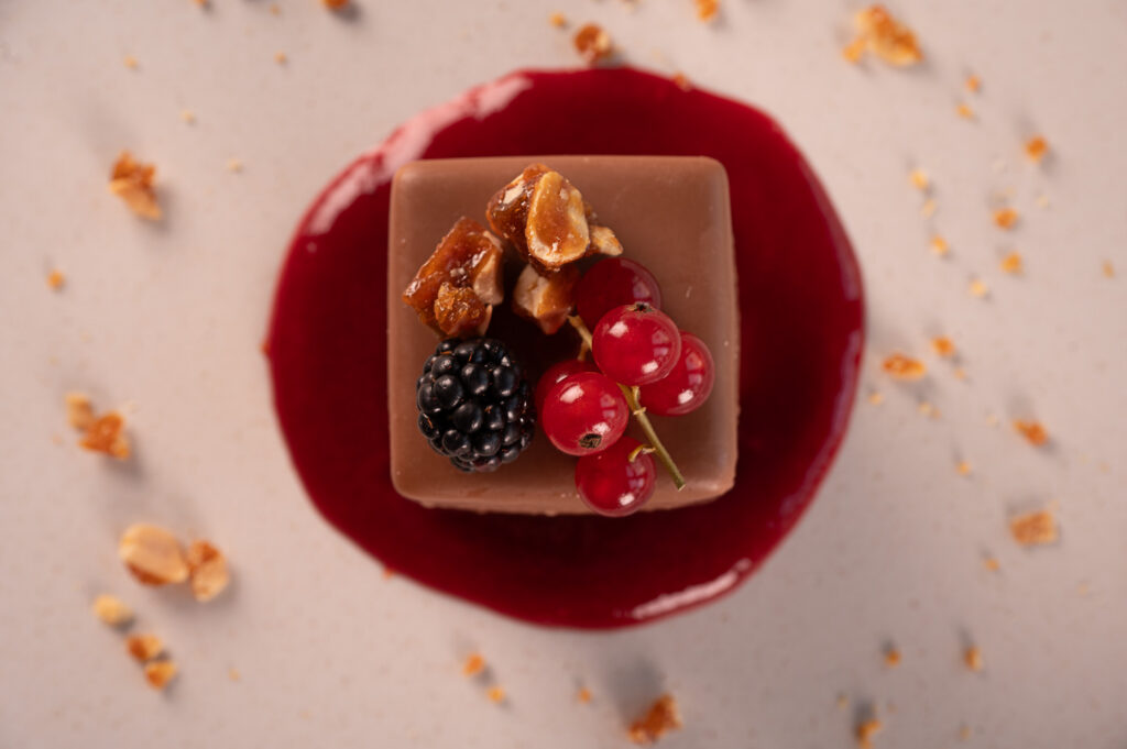Tavolozza di dolci e frutta in still life, con cioccolato, frutti rossi e salsa di frutti di bosco.